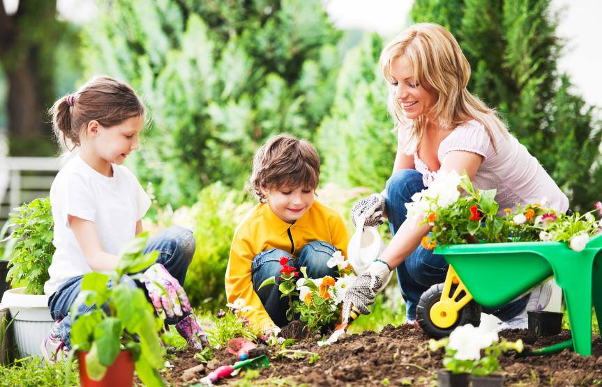 Mother, daughter and son planting flowers together