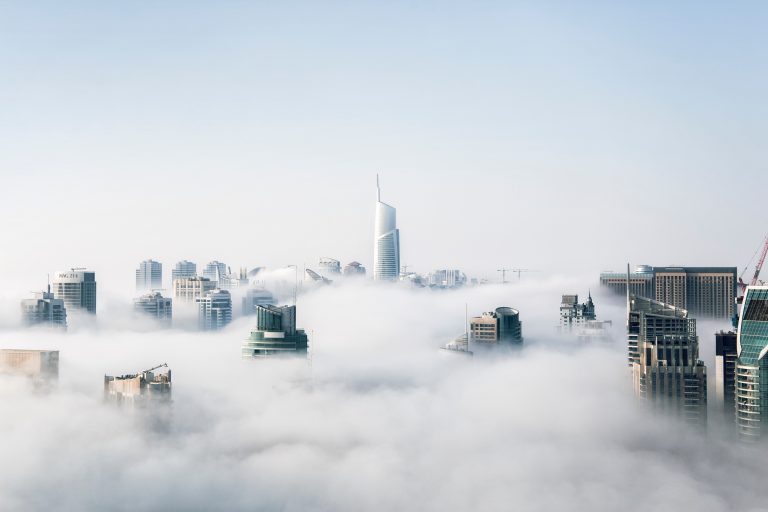 Commercial building tops pocking out of cloud cover